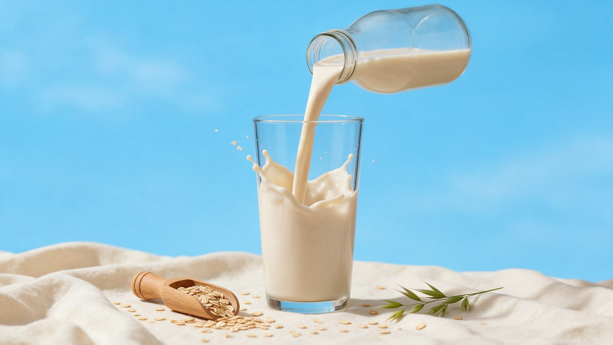 Oat milk pouring into a glass beside rolled oats